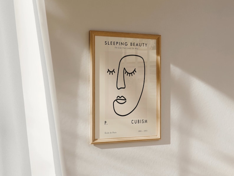 May include: A framed print with a black and white line drawing of a face with the text "SLEEPING BEAUTY The Love That Lasts The Way" and "CUBISM 1908 - 1917" and "P. Ecole de Paris" in the bottom right corner.