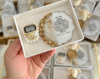 May include: A white gift box with a gold trim contains a digital prayer counter and a white resin coaster with gold accents. The coaster features Arabic calligraphy and the text "Special Gift" and "Flowers in Marble Harmony".