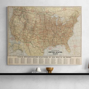 May include: A vintage map of the United States and Alaska showing radio broadcasting stations of 500 watts or more. The map is printed on a cream-colored paper with brown and red lines.
