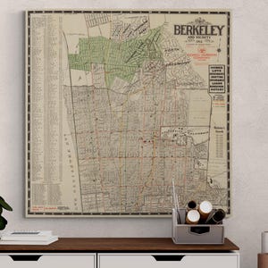 Puede incluir: Un mapa vintage de Berkeley, California, y sus alrededores de 1912. El mapa está impreso en papel color crema y presenta una cuadrícula de calles detallada con marcas rojas. El mapa está enmarcado y colgado en una pared sobre un estante de madera.