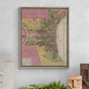 May include: A vintage map of Philadelphia, Pennsylvania, printed in shades of pink, yellow, and green. The map shows the city's streets and neighborhoods, with a key listing the names of each area.