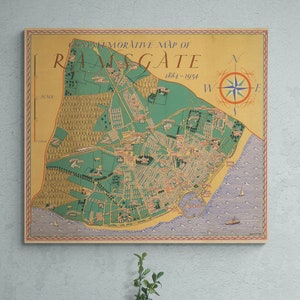 Puede incluir: Un mapa conmemorativo de Ramsgate, 1884-1934, de estilo vintage, con una rosa de los vientos. El mapa presenta detalles verdes, beige y rojos, que representan el diseño de la ciudad, la costa y los alrededores. El mapa está enmarcado y montado en una pared gris claro.