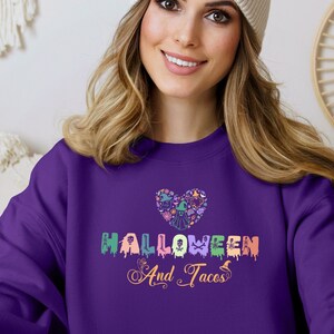 Funny I Love Halloween and Tacos Sweatshirt with a design in vibrant colors. Shirts are available in various colors.
