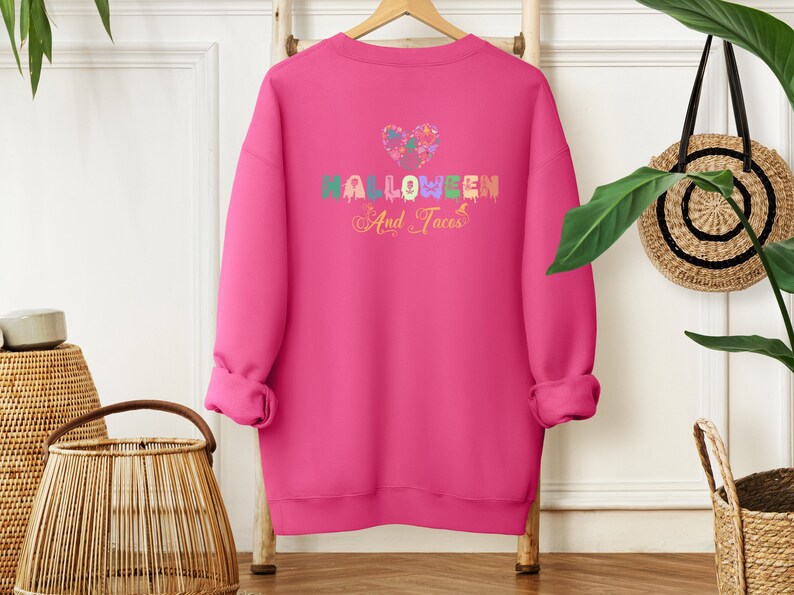 Funny I Love Halloween and Tacos Sweatshirt with a design in vibrant colors. Shirts are available in various colors.