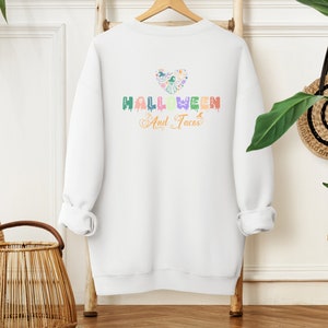 Funny I Love Halloween and Tacos Sweatshirt with a design in vibrant colors. Shirts are available in various colors.