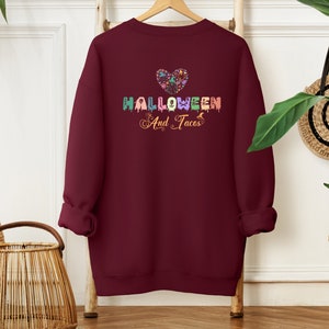 Funny I Love Halloween and Tacos Sweatshirt with a design in vibrant colors. Shirts are available in various colors.