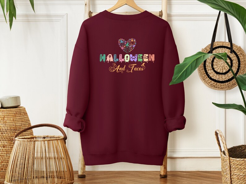 Funny I Love Halloween and Tacos Sweatshirt with a design in vibrant colors. Shirts are available in various colors.