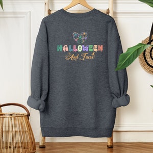 Funny I Love Halloween and Tacos Sweatshirt with a design in vibrant colors. Shirts are available in various colors.