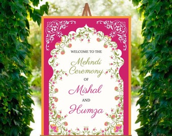 May include: A pink and white welcome sign with an ornate floral border. The sign reads "Welcome to the Mehndi Ceremony of Mishal and Humza".