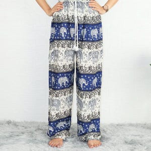 May include: Blue and white patterned pants with an elephant print. The pants have an elastic waistband and a drawstring.
