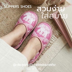 Peut inclure: Des chaussons roses avec un motif d'éléphant blanc. Les chaussons ont un bout arrondi et une semelle souple et rembourrée. Le texte "SLIPPERS SHOES" est en haut de l'image. Les chaussons sont sur un tapis à motifs.