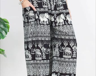 Puede incluir: Pantalones estampados en blanco y negro con un motivo de elefantes. Los pantalones tienen cintura con cordón y bolsillos. El diseño presenta elefantes y patrones decorativos repetidos. Fabricados en tejido ligero.