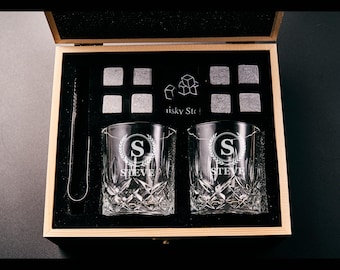 May include: A wooden gift box containing two engraved whiskey glasses, whiskey stones, and tongs. The glasses are etched with a monogram and the name "STEVE". The box also includes the text "risky Stone".