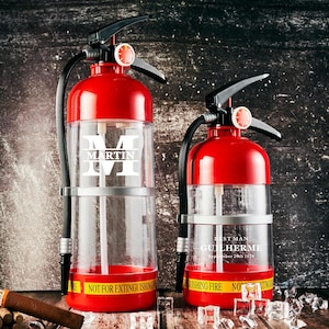 Peut inclure: Deux distributeurs de boissons rouges et transparents en forme d'extincteur. L'un porte l'inscription "MARTIN" en lettres blanches, l'autre "BEST MAN GUILHERME September 26th 2024". Les deux ont des poignées et des tuyaux noirs.