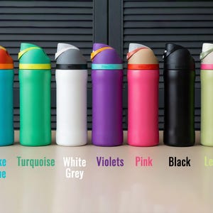 May include: A row of insulated water bottles in various colors: Lake Blue, Turquoise, White Grey, Violets, Pink, Black, and Lemon. Each bottle has a colored lid and a matching colored band around the base of the lid. The brand name is printed on the band.