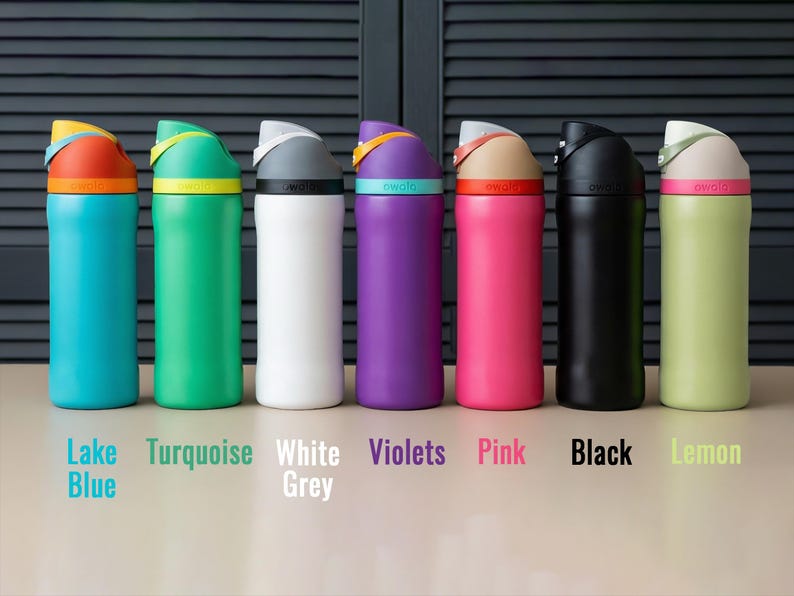 May include: A row of insulated water bottles in various colors: Lake Blue, Turquoise, White Grey, Violets, Pink, Black, and Lemon. Each bottle has a colored lid and a matching colored band around the base of the lid. The brand name is printed on the band.