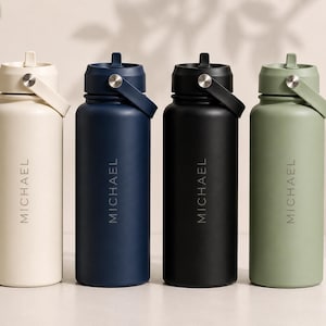 May include: Four cylindrical water bottles in cream, navy blue, black, and sage green. Each bottle features a matching lid with a carry handle, a silver-toned pivot pin, and the name MICHAEL printed vertically in a clean, sans-serif font.
