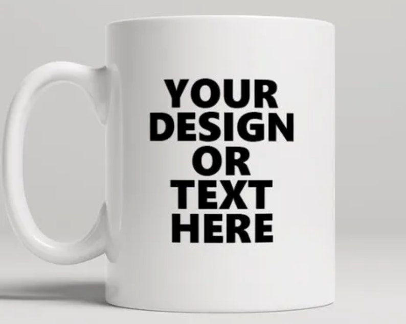 May include: White ceramic coffee mug with a black design that says "YOUR DESIGN OR TEXT HERE".