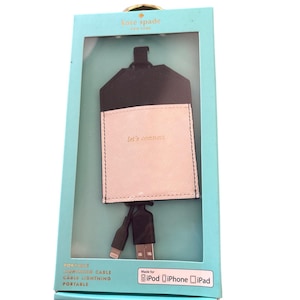 May include: Kate Spade New York portable charging cable set in a teal box. The set includes a black and white pouch with the text "let's connect" and a black lightning cable. Made for iPod, iPhone, and iPad.