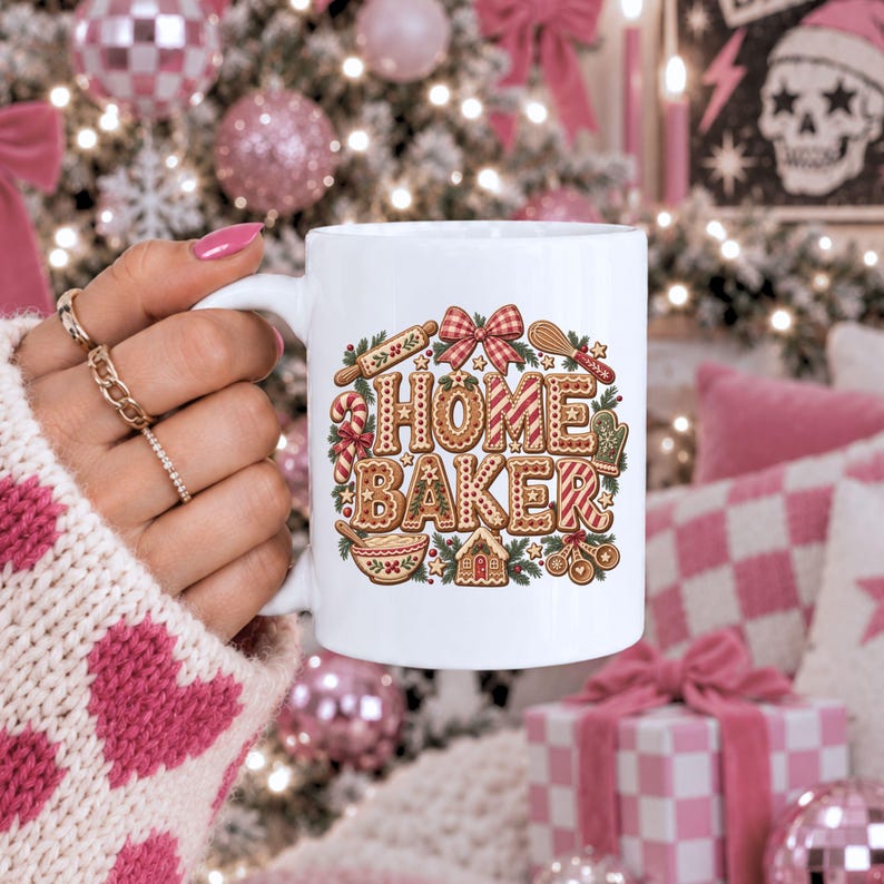 May include: A white ceramic mug featuring a colorful graphic of gingerbread-style letters spelling HOME BAKER, surrounded by illustrations of a rolling pin, whisk, candy cane, mixing bowl, measuring spoons, and a small gingerbread house.