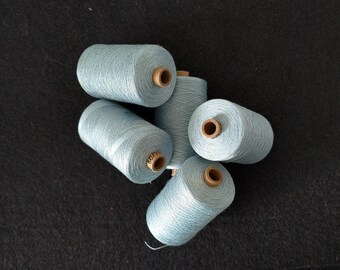 Könnte beinhalten: Fünf Spulen mit hellblauem Garn, jede mit einer braunen Mitte und einem Etikett mit der Aufschrift "6017".