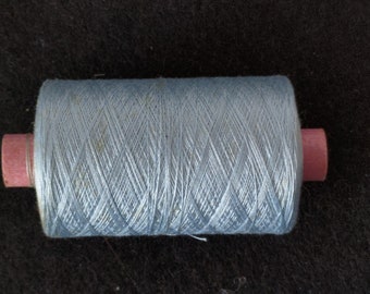 Könnte beinhalten: Eine Spule mit hellblauem Garn und rosafarbenen Plastikenden.