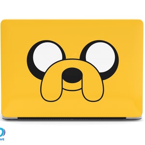 Puede incluir: Una piel de portátil amarilla con una cara de perro de dibujos animados en blanco y negro. El perro tiene ojos grandes y redondos y una nariz negra.