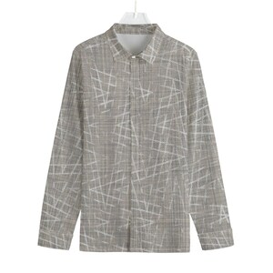 Può includere: Una camicia a maniche lunghe con bottoni e un motivo geometrico grigio e bianco.
