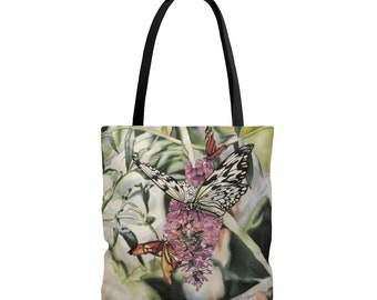 May include: A white tote bag with a floral design featuring butterflies. The butterflies are black and white with a few orange butterflies in the background. The flowers are pink and purple.