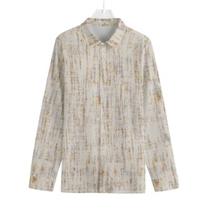Puede incluir: Una camisa de manga larga con botones, fondo blanco y estampado abstracto marrón y azul.