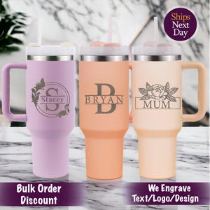 May include: Three stainless steel travel mugs with lids and straws. The mugs are in different colors: purple, peach, and beige. The mugs are engraved with the names "Stacey", "Bryan", and "Mum".