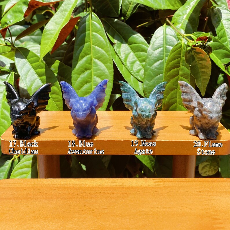 May include: Four small gargoyle figurines carved from different types of stone. The gargoyles are black obsidian, blue aventurine, moss agate, and flame stone.