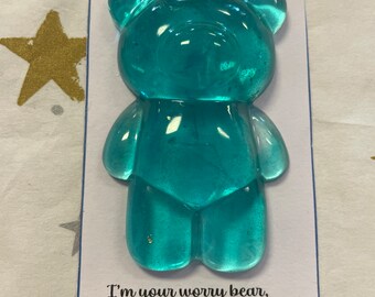 Op de afbeelding: Een blauwe worry bear met de tekst "WORRY BEAR" bovenaan en de tekst "I'm your worry bear, squeeze me tight. I'll help to make you feel alright." onderaan.