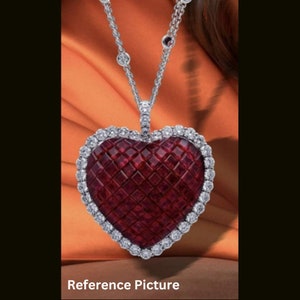 Könnte beinhalten: Eine silberne Kettenkette mit einem großen herzförmigen Anhänger. Der Anhänger besteht aus roten Rubin-Steinen, die in einen Diamanten-Halo gefasst sind.