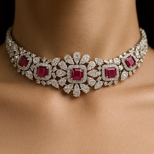 Puede incluir: Un collar deslumbrante con una serie de piedras preciosas rojas cuadradas engastadas en un diseño floral. El collar está incrustado con numerosas piedras preciosas pequeñas y transparentes, creando una apariencia lujosa y brillante. El collar está diseñado para el cuello.
