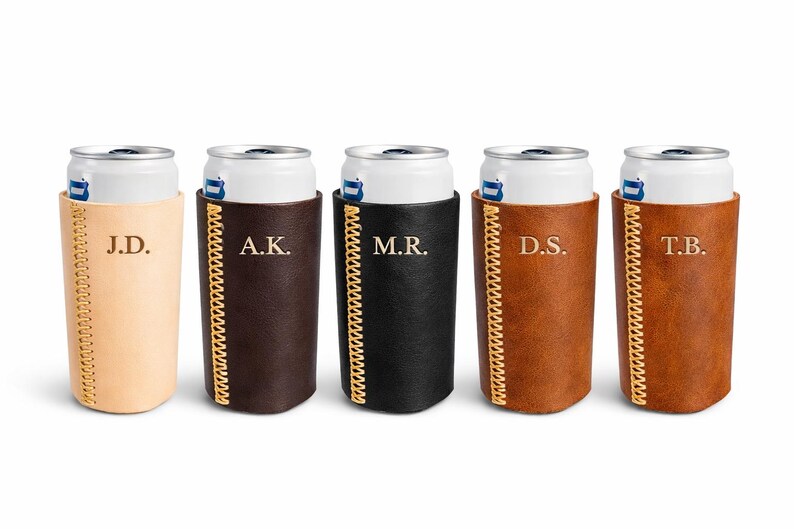 May include: Five personalized leather can coolers in various colors: tan, dark brown, black, medium brown, and light brown. Each cooler has initials stitched in gold thread and a matching gold-colored zipper.