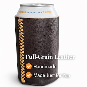 May include: A dark brown full-grain leather can cooler with a yellow stitched seam. The can cooler has the words "Full-Grain Leather", "Handmade", and "Made Just for You" printed on it. A can of unsweetened lemon beverage is inside.