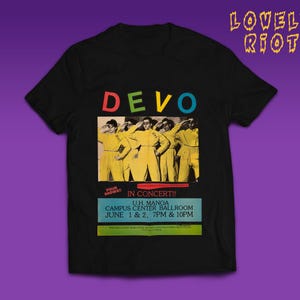 Può includere: T-shirt nero con un design di poster di un concerto per la band DEVO. Il poster include il nome della band in lettere colorate, un'immagine dei membri della band e i dettagli del concerto: U.H. Manoa Campus Center Ballroom, 1 e 2 giugno.
