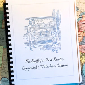 May include: A vintage book cover with a blue illustration of two girls in a classroom setting. The text on the cover reads "McGuffey's Third Reader Copywork: D'Nealian Cursive".