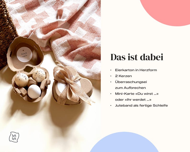 K&ouml;nnte beinhalten: Ein herzf&ouml;rmiger Eierkarton mit zwei gesprenkelten Eiern und einem wei&szlig;en Ei. Ein zweiter herzf&ouml;rmiger Beh&auml;lter mit einer Schleife befindet sich neben dem Karton. Der Text "Knack mich" steht auf einem kleinen runden Aufkleber.
