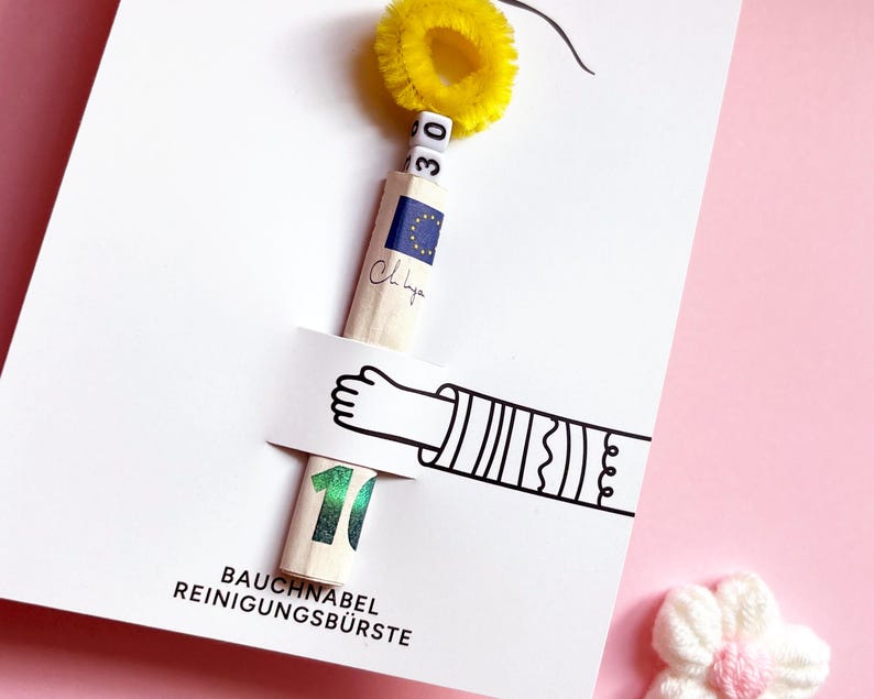 May include: A white greeting card featuring a graphic of an arm holding a rolled-up ten euro banknote. The banknote is topped with white letter beads spelling 30 and a yellow fuzzy pipe cleaner. The text reads BAUCHNABEL REINIGUNGSB&Uuml;RSTE.