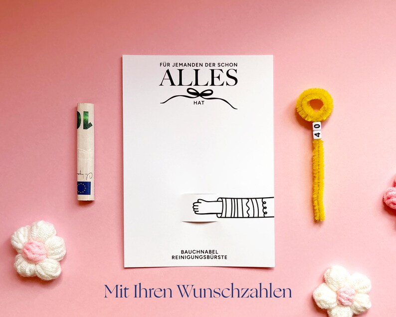 May include: A white rectangular card with black text reading F&Uuml;R JEMANDEN DER SCHON ALLES HAT and BAUCHNABEL REINIGUNGSB&Uuml;RSTE, featuring a graphic of a hand. Beside it is a rolled banknote and a yellow pipe cleaner with the number 40 on beads.