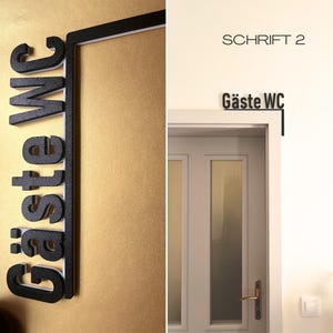 May include: Black and white sign that reads "G&auml;ste WC" in a stylized font. The sign is mounted on a gold-colored wall. The second image shows the text "SCHRIFT 2" above the text "G&auml;ste WC" on a white wall.