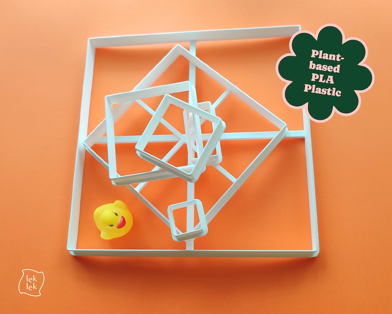May include: White geometric cookie cutters in various sizes are arranged on an orange surface. A yellow rubber duck is also present. A green flower-shaped graphic reads "Plant-based PLA Plastic".