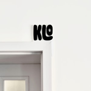 Könnte beinhalten: Eine weiße Tür mit einem schwarzen Schild darüber, auf dem "KLO" steht.