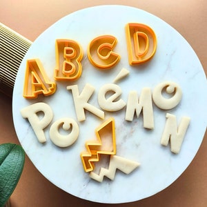 Cortadores de galletas de Pokémon, alfabeto, cortador de fondant, cortador de galletas con letras, juego de 26 letras de la A a la Z, adornos para cupcakes, fuente de Pokémon de arcilla y números.
