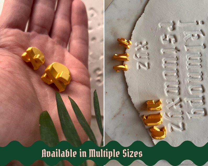May include: A set of small, three-dimensional golden letter stamps used for embossing. The letters are shown in various sizes, with some held in a palm and others placed next to a white clay surface featuring impressed alphabet characters.
