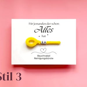 以下が含まれることがあります： ドイツ語のテキストと、へそクリーナーの形をした黄色のパイプクリーナーが付いた白いカード。カードには「F&uuml;r jemanden der schon Alles hat」と「Bauchnabel Reinigungsb&uuml;rste」という言葉が印刷されています。「30」の数字が表示されています。