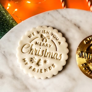 May include: White ceramic Christmas cookie stamp with the text "We wish you a Merry Christmas My Friends" and a bow, snowflake, and Christmas tree design.
