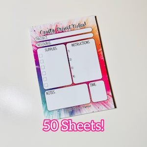 May include: A notepad with a colorful watercolor background and the text "Crafty Project Notes!"  The notepad has sections for project, resource, supplies, instructions, notes, and time. It includes 50 sheets.